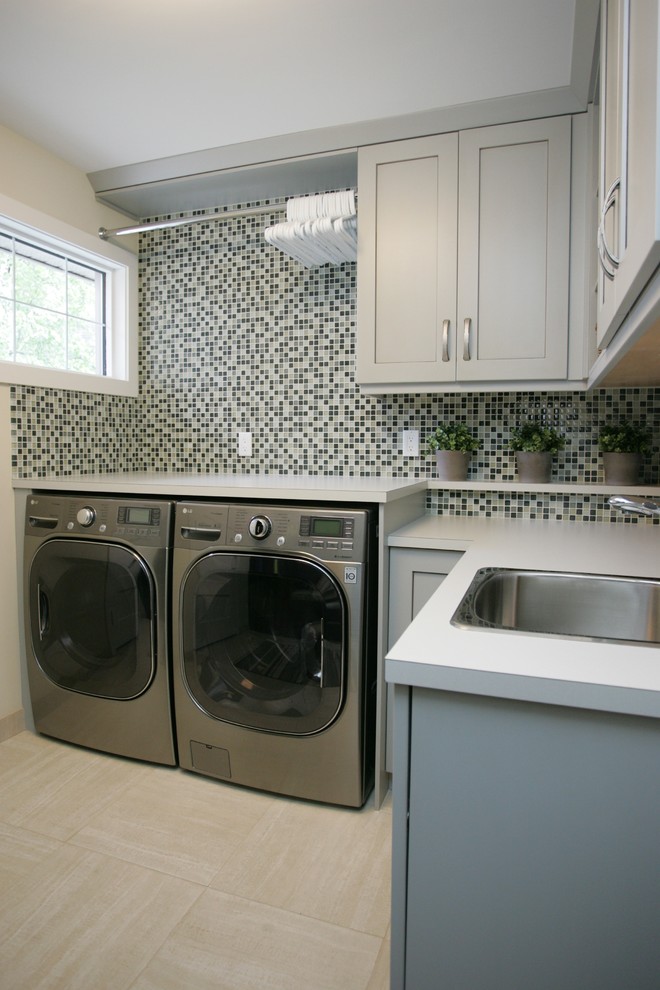 Immagine di una sala lavanderia chic con lavello da incasso, ante in stile shaker, ante grigie e lavatrice e asciugatrice affiancate
