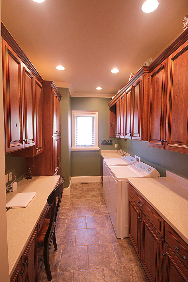 Large elegant galley vinyl floor utility room photo in Other with an integrated sink, raised-panel cabinets, medium tone wood cabinets, solid surface countertops, green walls and a side-by-side washer/dryer