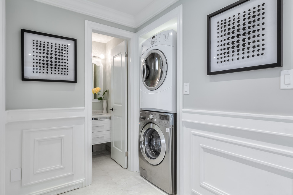 Foto di un ripostiglio-lavanderia tradizionale con pareti grigie, lavatrice e asciugatrice a colonna e pavimento grigio