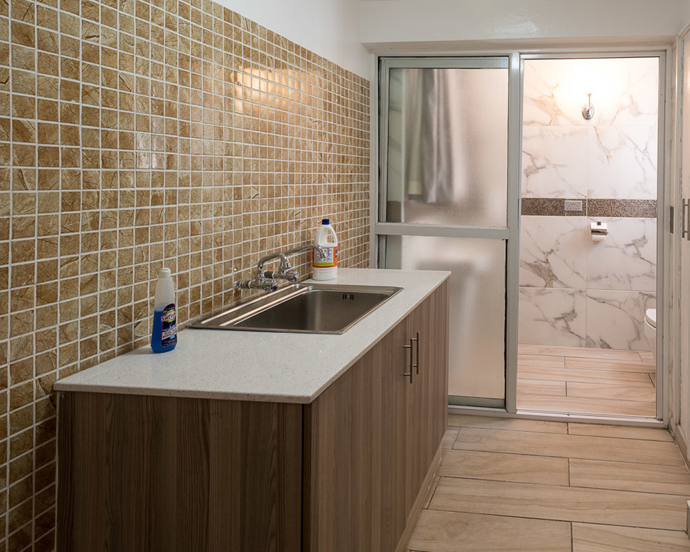 This is an example of a small modern single-wall utility room in Other with a built-in sink, flat-panel cabinets, brown cabinets, limestone worktops, ceramic flooring, brown floors, white worktops and white walls.