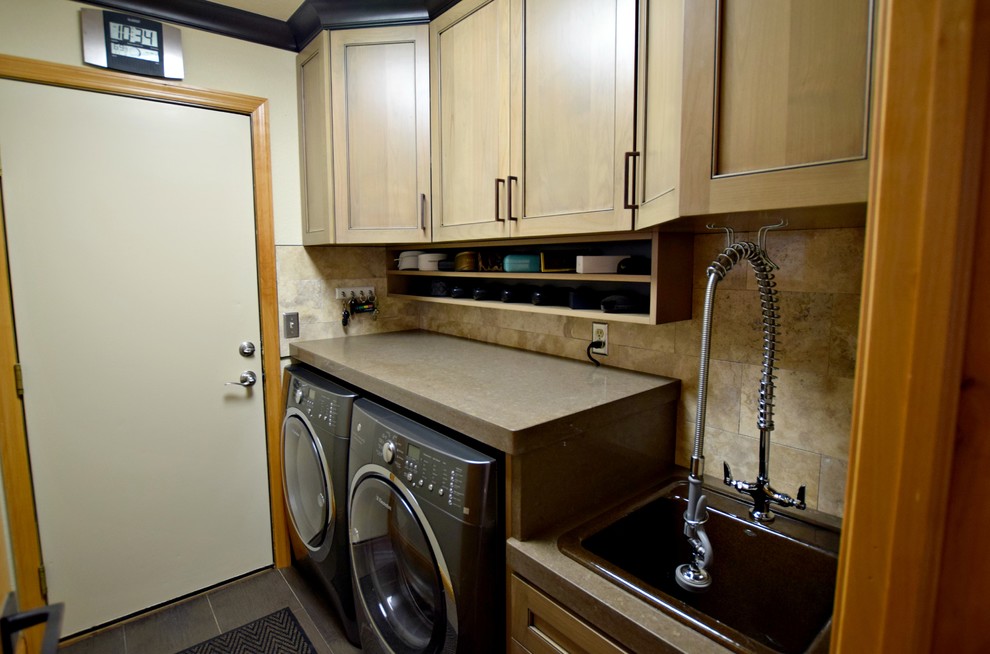 Photo of a small traditional single-wall separated utility room in Denver with a side by side washer and dryer, recessed-panel cabinets, medium wood cabinets and a built-in sink.