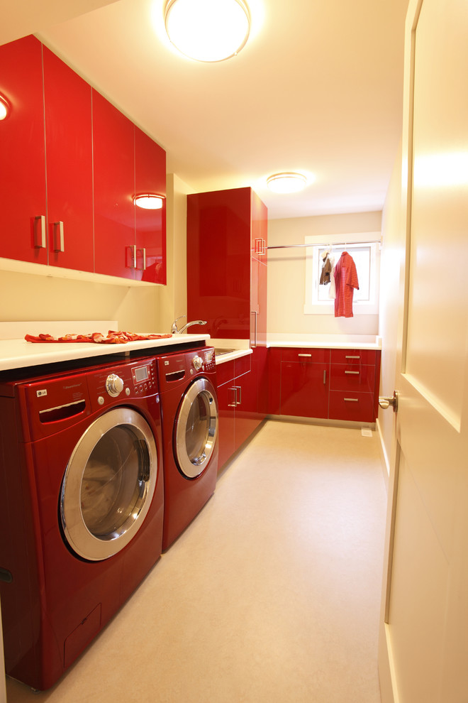 Modelo de lavadero contemporáneo con puertas de armario rojas y encimeras blancas