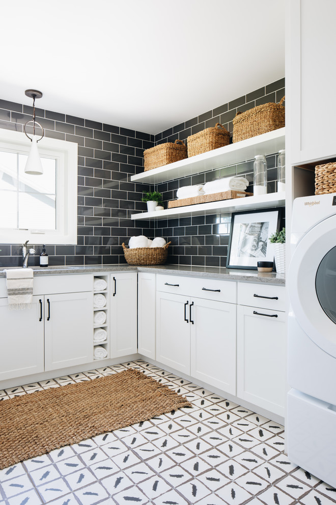 Esempio di una lavanderia multiuso country con lavello sottopiano, ante in stile shaker, ante bianche, pareti nere, lavatrice e asciugatrice affiancate, pavimento bianco e top grigio