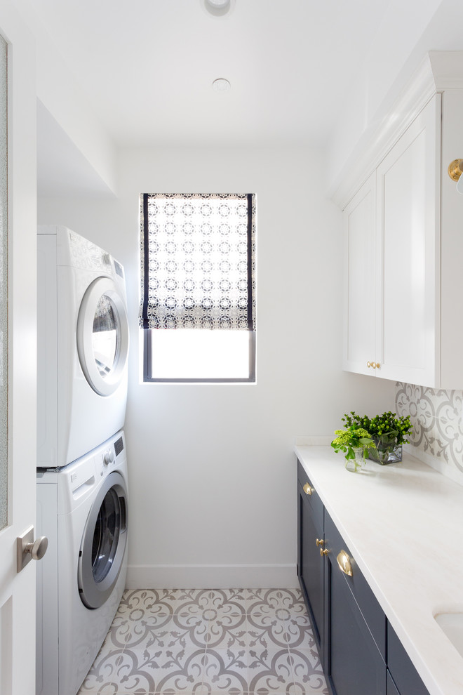 Idéer för en maritim vita parallell tvättstuga enbart för tvätt, med en undermonterad diskho, skåp i shakerstil, blå skåp, vita väggar och en tvättpelare