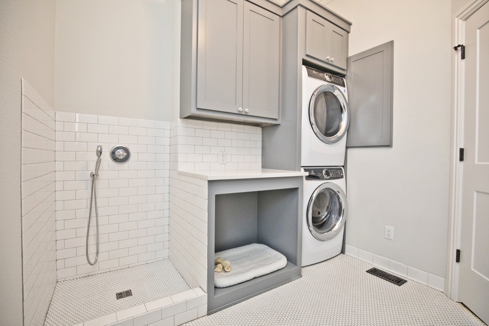 Example of a mid-sized transitional single-wall dedicated laundry room design in Other with shaker cabinets, gray cabinets, gray walls, a stacked washer/dryer and white countertops
