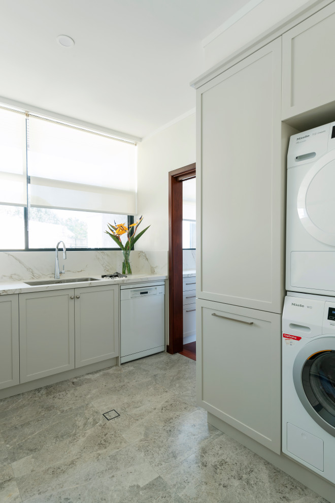 Design ideas for a medium sized traditional u-shaped utility room in Perth with a submerged sink, shaker cabinets, grey cabinets, composite countertops, white walls, porcelain flooring, a stacked washer and dryer, grey floors and multicoloured worktops.
