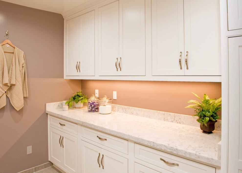 Photo of a large traditional u-shaped separated utility room in Orange County with a submerged sink, beaded cabinets, white cabinets, engineered stone countertops, purple walls, porcelain flooring and a side by side washer and dryer.