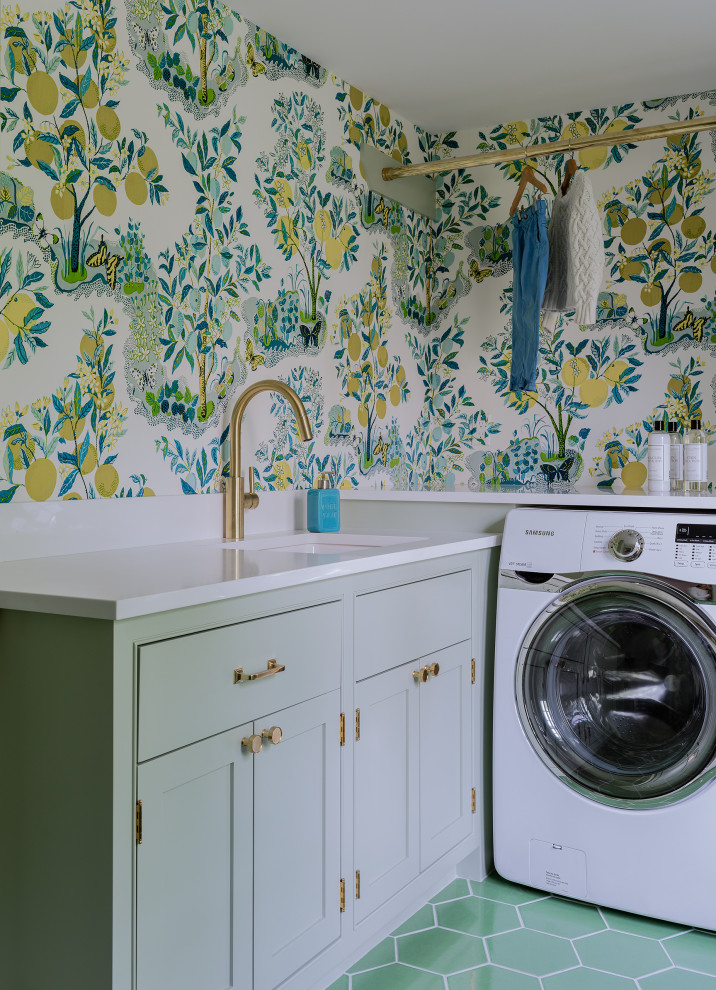 Modelo de cuarto de lavado en L tradicional con fregadero bajoencimera, puertas de armario verdes, encimera de cuarzo compacto, suelo de baldosas de cerámica, lavadora y secadora juntas y suelo verde