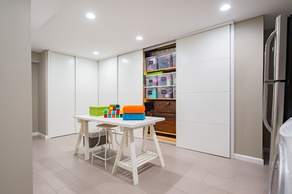 Источник вдохновения для домашнего уюта: большая универсальная комната в современном стиле с серыми стенами, со стиральной и сушильной машиной рядом, серым полом и полом из ламината