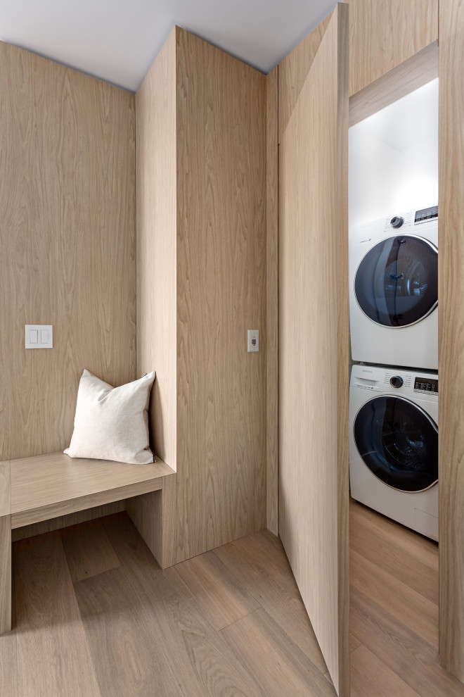 Immagine di una piccola lavanderia contemporanea con pareti bianche, parquet chiaro, pavimento marrone e pareti in legno