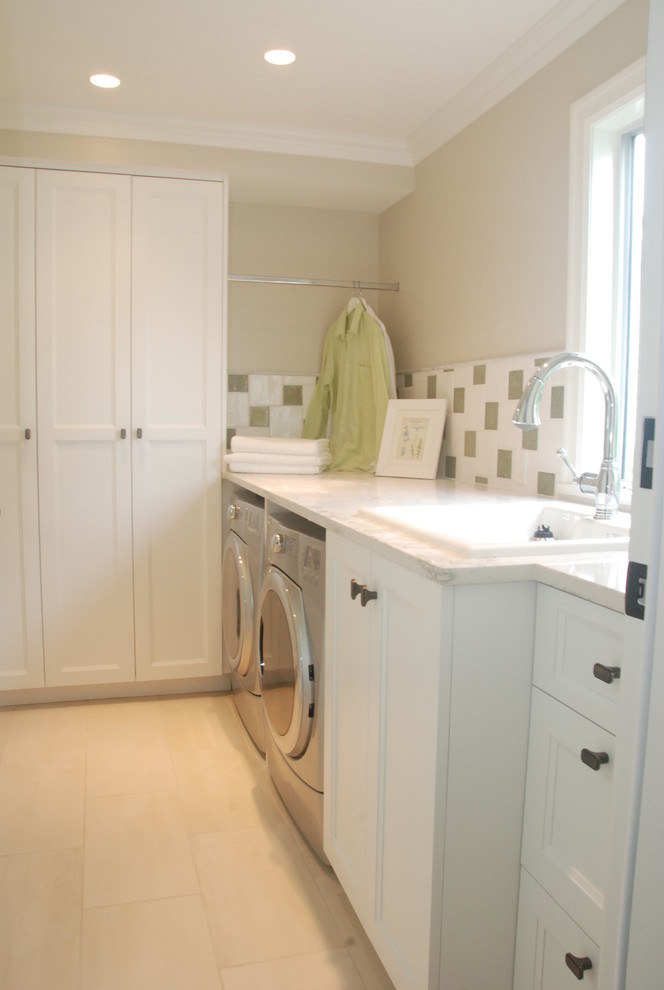 Photo of a medium sized traditional single-wall separated utility room in Vancouver with an utility sink, shaker cabinets, white cabinets, quartz worktops, beige walls, porcelain flooring, a side by side washer and dryer and beige floors.