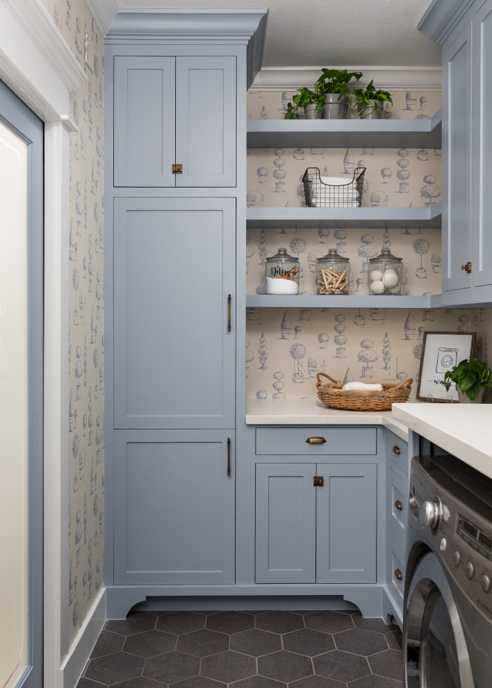 Foto di una lavanderia tradizionale con ante in stile shaker, ante blu, pareti beige, lavatrice e asciugatrice affiancate, pavimento grigio e top bianco