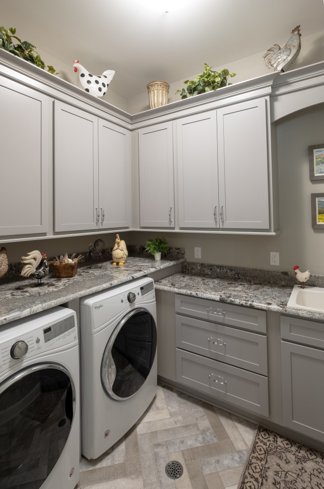 Imagen de cuarto de lavado en L tradicional renovado de tamaño medio con pila para lavar, armarios estilo shaker, puertas de armario grises, paredes beige, lavadora y secadora juntas y encimeras grises