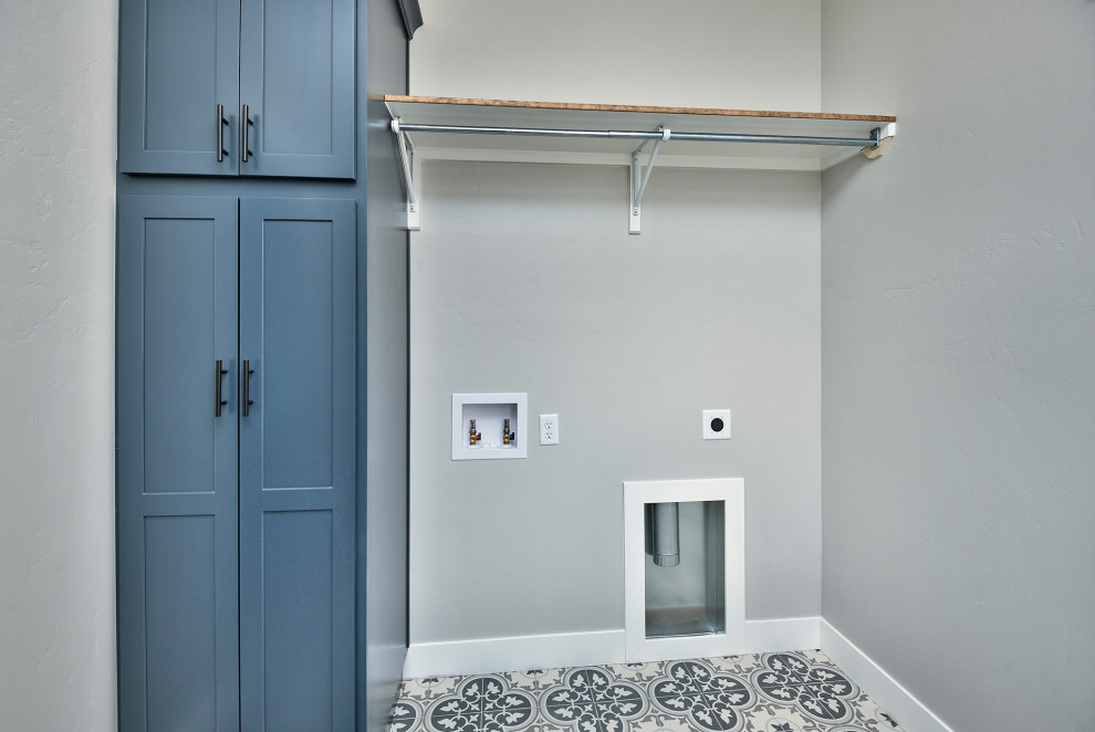 Utility room - mid-sized rustic single-wall vinyl floor and gray floor utility room idea in Other with recessed-panel cabinets, blue cabinets, gray walls and a side-by-side washer/dryer