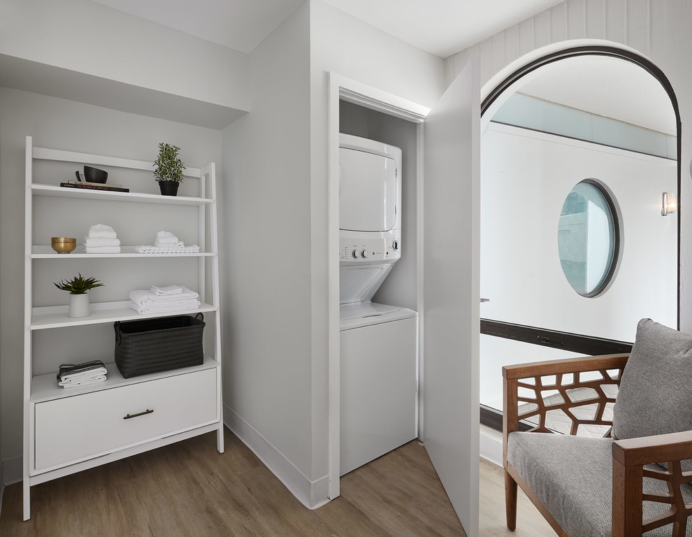 Exempel på en modern liten tvättstuga, med grå väggar, ljust trägolv, en tvättpelare och beiget golv