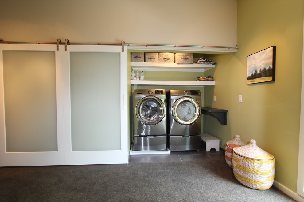 Idéer för en liten modern liten tvättstuga, med klinkergolv i porslin, en tvättmaskin och torktumlare bredvid varandra och gröna väggar