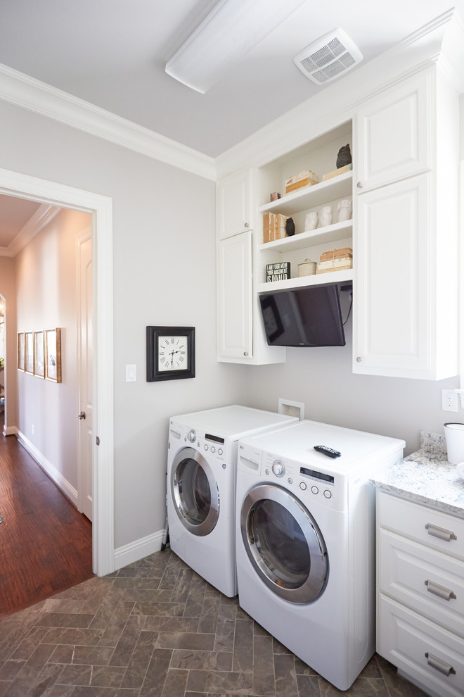 Inspiration för mellanstora klassiska linjära tvättstugor enbart för tvätt, med grå väggar, en tvättmaskin och torktumlare bredvid varandra, grått golv, luckor med upphöjd panel, vita skåp, bänkskiva i kvartsit och skiffergolv