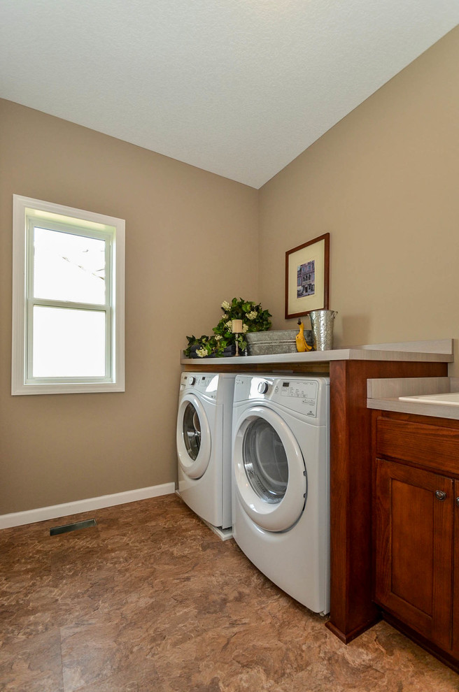 Foto di una sala lavanderia classica con lavello da incasso, ante lisce, ante in legno scuro, top in laminato, pareti beige e lavatrice e asciugatrice affiancate