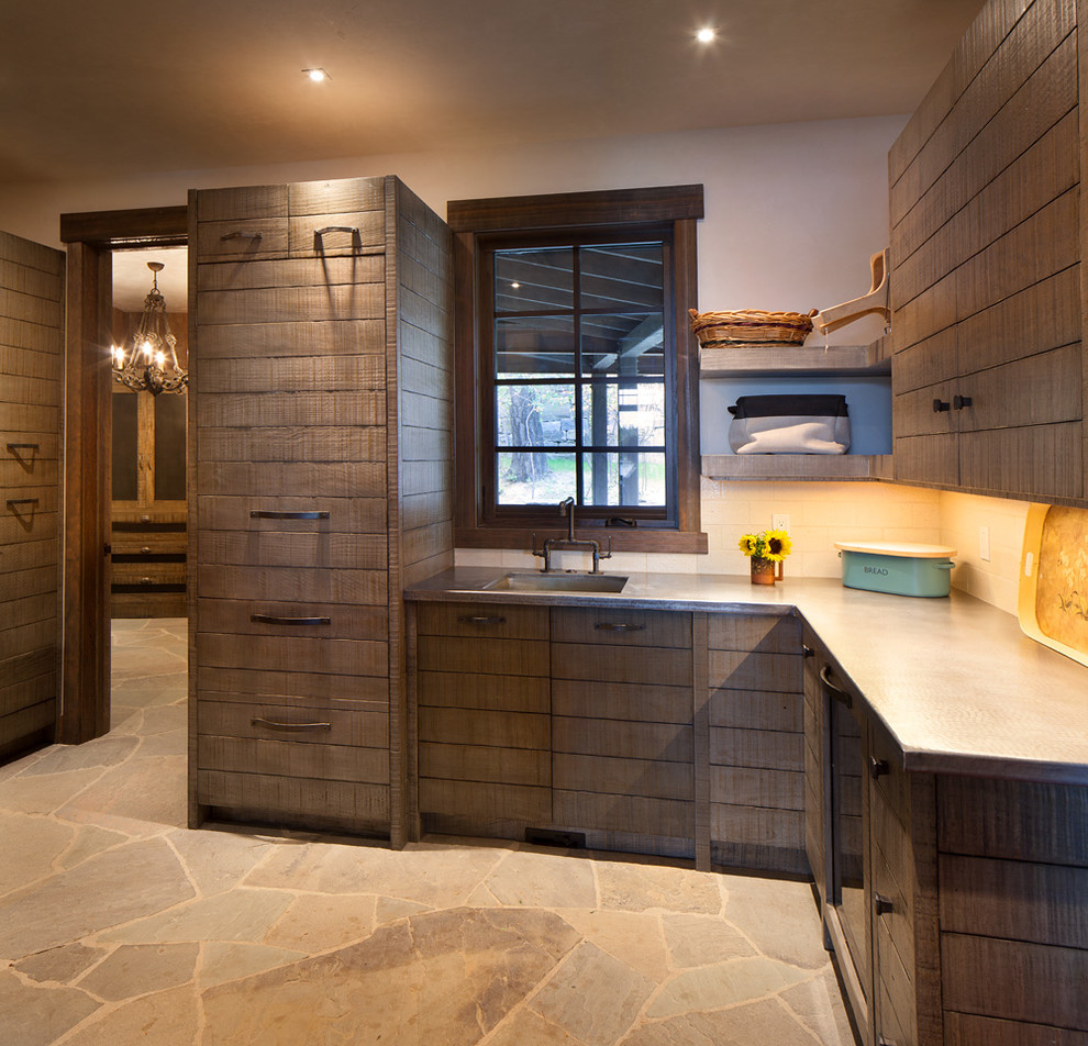 Large rustic u-shaped utility room in Seattle with a submerged sink, dark wood cabinets, beige walls and beige floors.