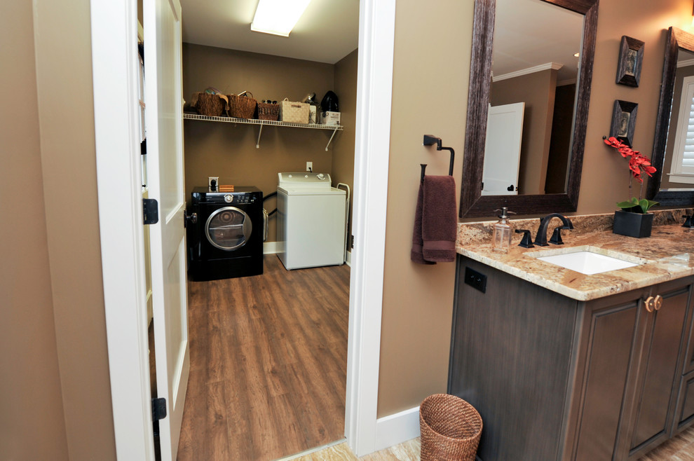 Medium sized traditional galley separated utility room in Birmingham with an utility sink, brown walls, vinyl flooring and a side by side washer and dryer.