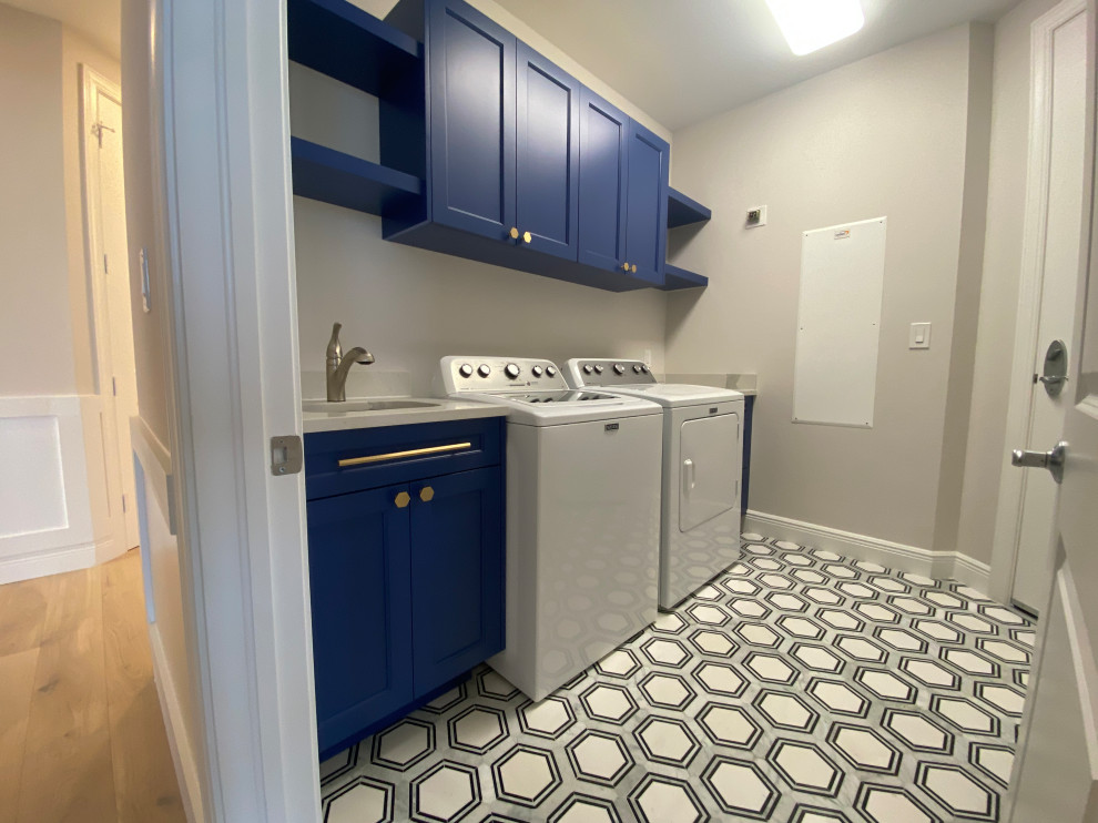 マイアミにある高級な中くらいなコンテンポラリースタイルのおしゃれな洗濯室 (I型、アンダーカウンターシンク、シェーカースタイル扉のキャビネット、青いキャビネット、珪岩カウンター、白いキッチンパネル、クオーツストーンのキッチンパネル、白い壁、大理石の床、左右配置の洗濯機・乾燥機、白い床、白いキッチンカウンター、折り上げ天井) の写真