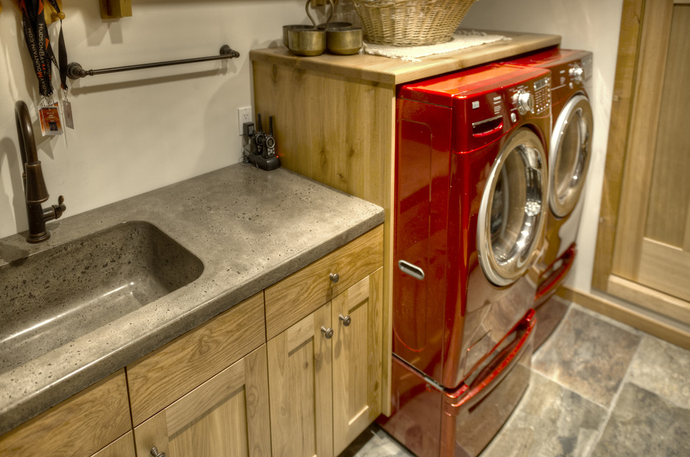 Idéer för att renovera en mellanstor rustik grå grått tvättstuga enbart för tvätt, med en integrerad diskho, skåp i shakerstil, skåp i mellenmörkt trä, bänkskiva i betong, vita väggar, skiffergolv, en tvättmaskin och torktumlare bredvid varandra och brunt golv