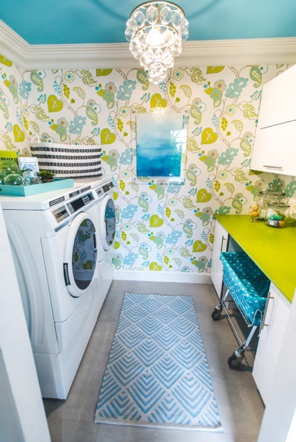 Exempel på en liten modern parallell tvättstuga enbart för tvätt, med släta luckor, vita skåp, bänkskiva i kvarts, flerfärgade väggar, klinkergolv i keramik och en tvättmaskin och torktumlare bredvid varandra