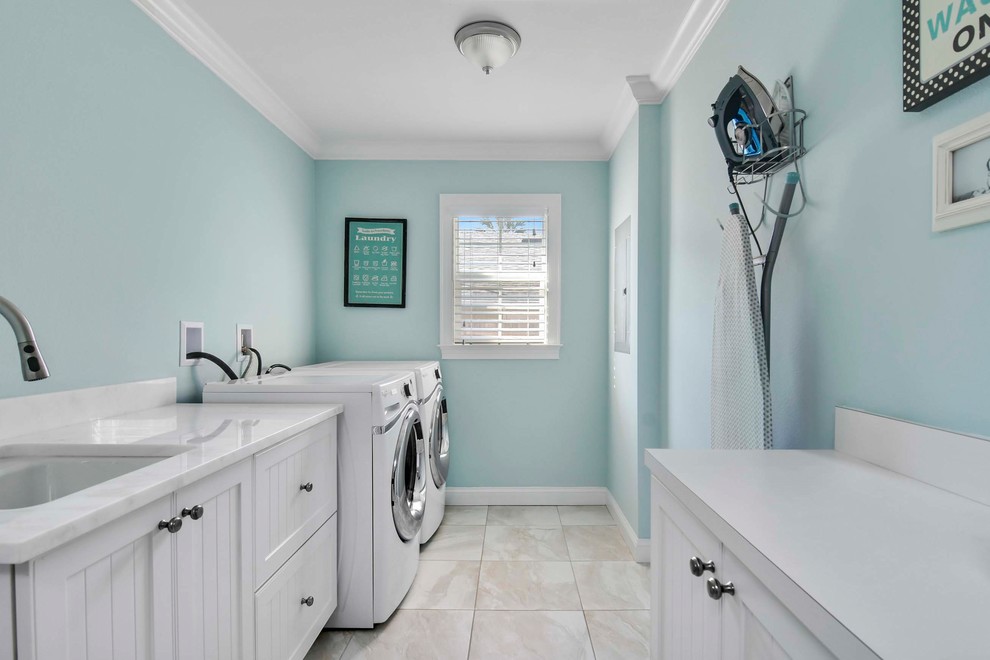 Design ideas for a medium sized coastal galley separated utility room in Orlando with a submerged sink, shaker cabinets, white cabinets, engineered stone countertops, blue walls, porcelain flooring and a side by side washer and dryer.
