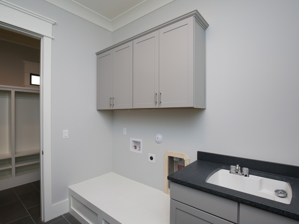 Medium sized classic galley utility room in Raleigh with a submerged sink, shaker cabinets, grey cabinets, granite worktops, grey walls, ceramic flooring, a side by side washer and dryer, grey floors and black worktops.