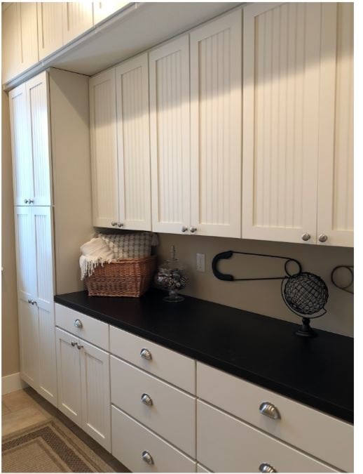 Design ideas for a medium sized classic galley separated utility room in Minneapolis with an utility sink, recessed-panel cabinets, white cabinets, laminate countertops, beige walls, porcelain flooring, a side by side washer and dryer, beige floors and black worktops.