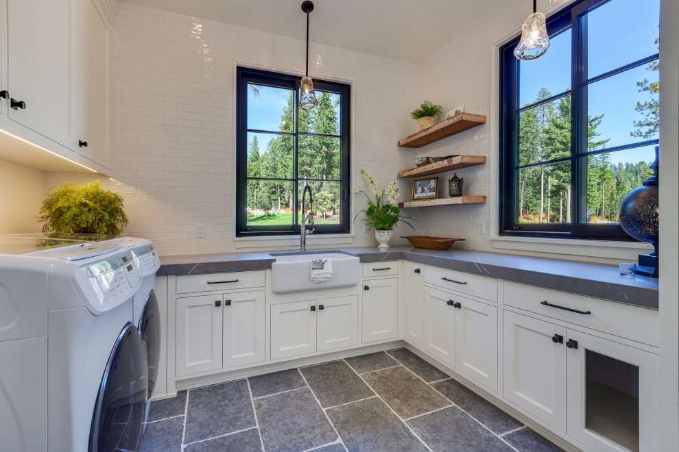 Inspiration for a transitional u-shaped gray floor laundry room remodel in Seattle with a farmhouse sink, shaker cabinets, white cabinets, a side-by-side washer/dryer and gray countertops