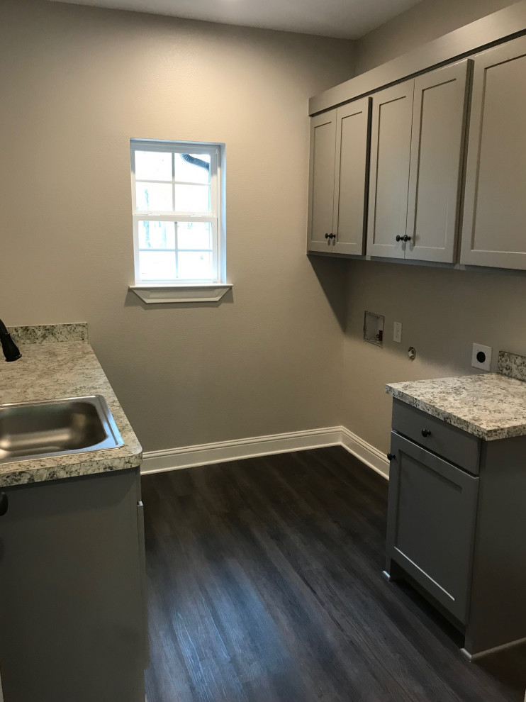 Inspiration for a mid-sized timeless u-shaped medium tone wood floor and brown floor utility room remodel in Dallas with a drop-in sink, recessed-panel cabinets, gray cabinets, laminate countertops, gray walls, a side-by-side washer/dryer and multicolored countertops