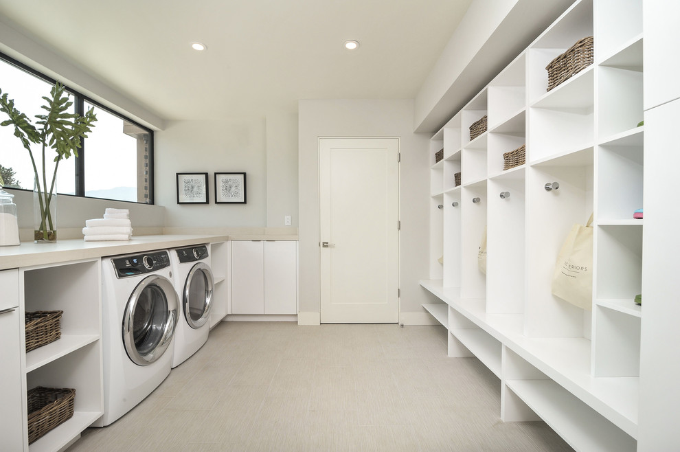 Diseño de cuarto de lavado actual grande con fregadero bajoencimera, armarios con paneles lisos, puertas de armario blancas, encimera de cuarcita, paredes blancas y lavadora y secadora juntas