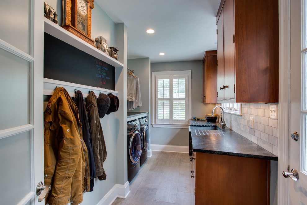 Immagine di una lavanderia classica con lavello stile country, top in saponaria, pareti grigie, pavimento in gres porcellanato e lavatrice e asciugatrice affiancate