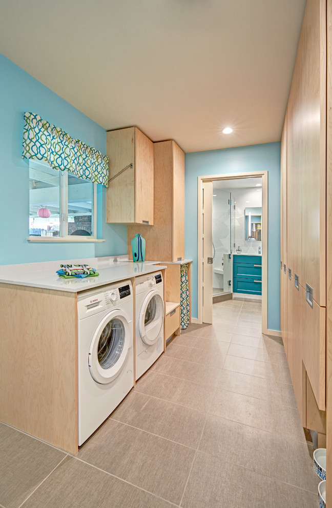 Mid-sized trendy galley porcelain tile utility room photo in Sacramento with flat-panel cabinets, light wood cabinets, quartz countertops, blue walls and a side-by-side washer/dryer