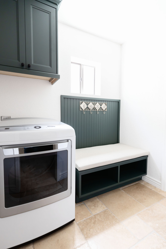 Inredning av en lantlig mellanstor tvättstuga, med en rustik diskho, skåp i shakerstil, gröna skåp, beiget golv, vita väggar, travertin golv och en tvättmaskin och torktumlare bredvid varandra