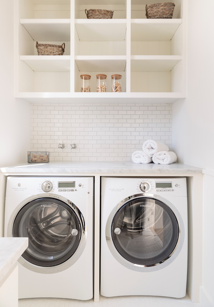Foto de lavadero marinero con lavadora y secadora juntas, armarios abiertos y puertas de armario blancas