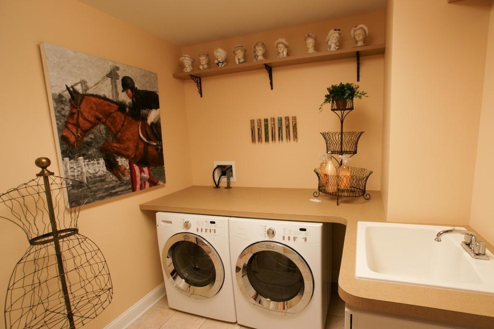 Mid-sized minimalist l-shaped ceramic tile dedicated laundry room photo in Boston with a drop-in sink, laminate countertops, beige walls and a side-by-side washer/dryer