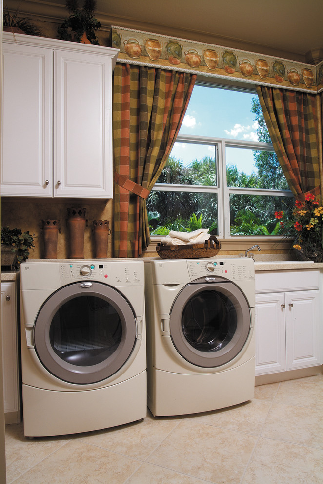 Foto på en stor medelhavsstil l-formad tvättstuga enbart för tvätt, med en nedsänkt diskho, luckor med upphöjd panel, vita skåp, bänkskiva i koppar, beige väggar, klinkergolv i keramik och en tvättmaskin och torktumlare bredvid varandra