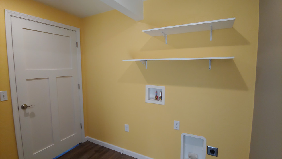 Esempio di una piccola lavanderia multiuso country con pareti gialle, pavimento in vinile, lavatrice e asciugatrice affiancate e pavimento marrone