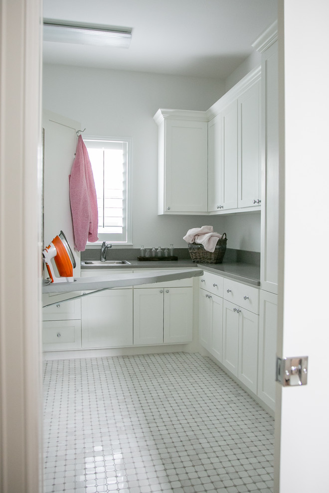 Immagine di una sala lavanderia scandinava di medie dimensioni con lavello da incasso, ante in stile shaker, ante bianche, pareti grigie, pavimento grigio e top grigio