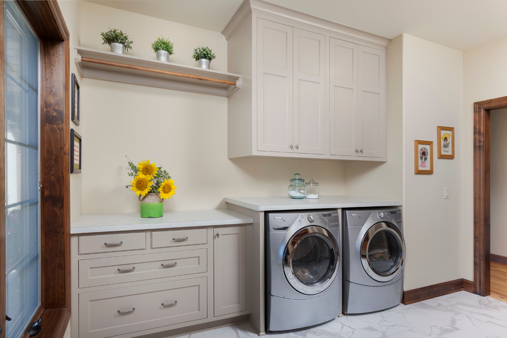 Mid-sized elegant galley ceramic tile dedicated laundry room photo in Milwaukee with flat-panel cabinets, beige cabinets, laminate countertops, beige walls and a side-by-side washer/dryer