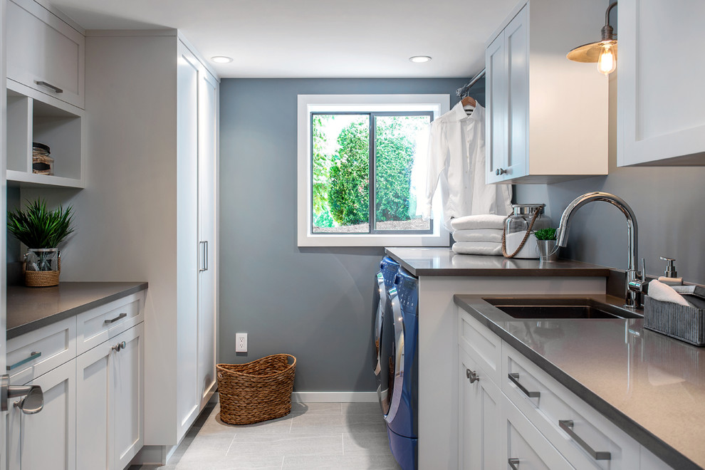 Photo of a classic galley utility room in Vancouver with a submerged sink, shaker cabinets, white cabinets, grey walls, a side by side washer and dryer, grey floors and grey worktops.