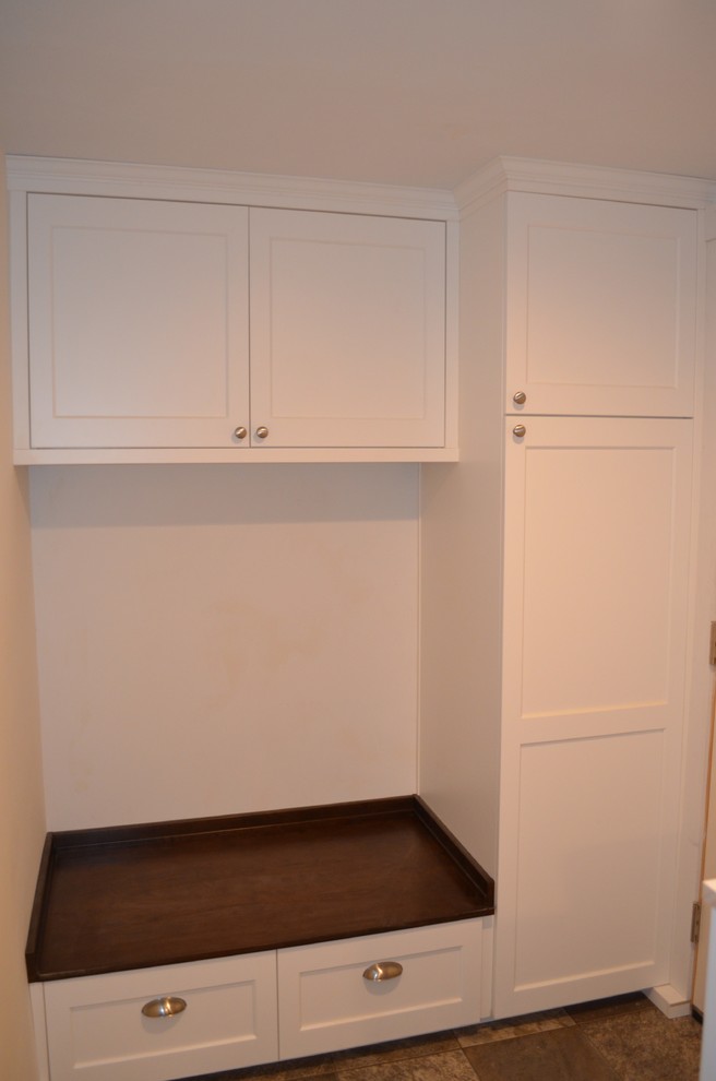 Cette image montre une petite buanderie parallèle traditionnelle multi-usage avec un placard à porte shaker, des portes de placard blanches, un plan de travail en bois, un mur beige, un sol en vinyl et des machines côte à côte.