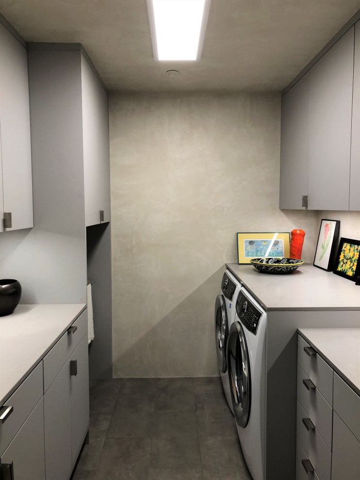 Mid-sized trendy galley gray floor dedicated laundry room photo in Other with an undermount sink, flat-panel cabinets, gray cabinets, beige walls, a side-by-side washer/dryer and gray countertops