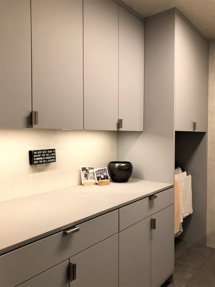 Mid-sized trendy galley gray floor dedicated laundry room photo in Other with an undermount sink, flat-panel cabinets, gray cabinets, beige walls, a side-by-side washer/dryer and gray countertops