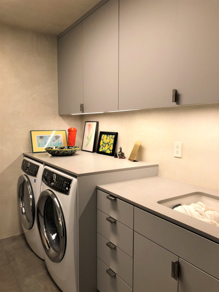 Inspiration for a mid-sized contemporary galley gray floor dedicated laundry room remodel in Other with an undermount sink, flat-panel cabinets, gray cabinets, beige walls, a side-by-side washer/dryer and gray countertops