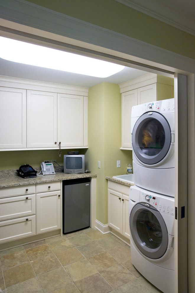 Idéer för en stor klassisk u-formad tvättstuga enbart för tvätt, med en nedsänkt diskho, luckor med infälld panel, vita skåp, granitbänkskiva, gula väggar, kalkstensgolv och en tvättpelare