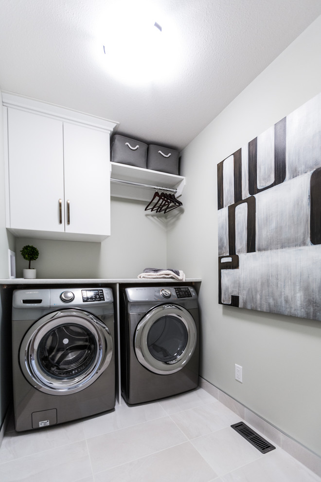 Esempio di una piccola sala lavanderia design con ante lisce, ante bianche, top in laminato, pareti grigie, pavimento in gres porcellanato e lavatrice e asciugatrice affiancate