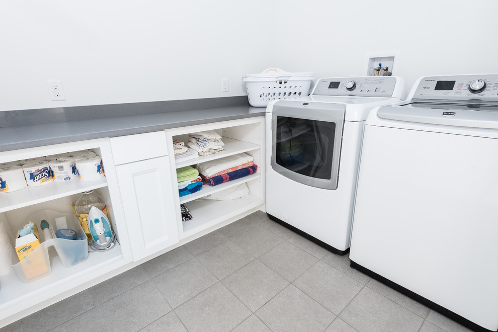 Small elegant l-shaped porcelain tile dedicated laundry room photo in Providence with open cabinets, white cabinets, laminate countertops, white walls, a side-by-side washer/dryer and gray countertops